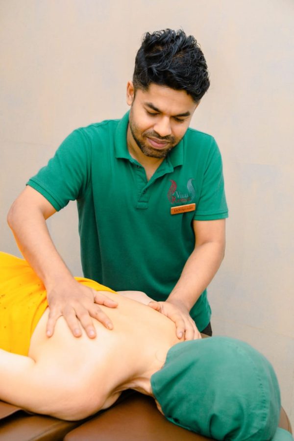 Therapeut Udaya massiert eine Klientin: Ayuredische Öl-Massage, Bild mit Schultern-Nacken-Massage