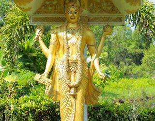 Ayurveda Gott Dhanvantari; handgemachte Skulptur im Resort der Villa, glänzt golden in der Sonne